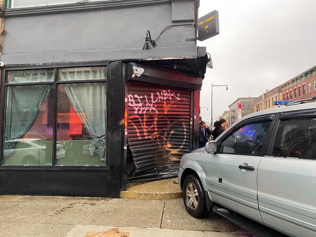 A car crashed into a building in Crown Heights, smashing the gate of a bar, on April 6, 2022.